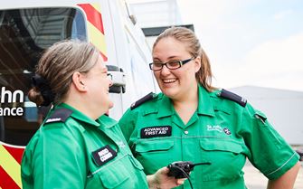 Two Advanced First Aiders by an ambulance