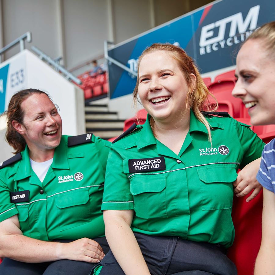 Two First Aiders smiling with member of the public