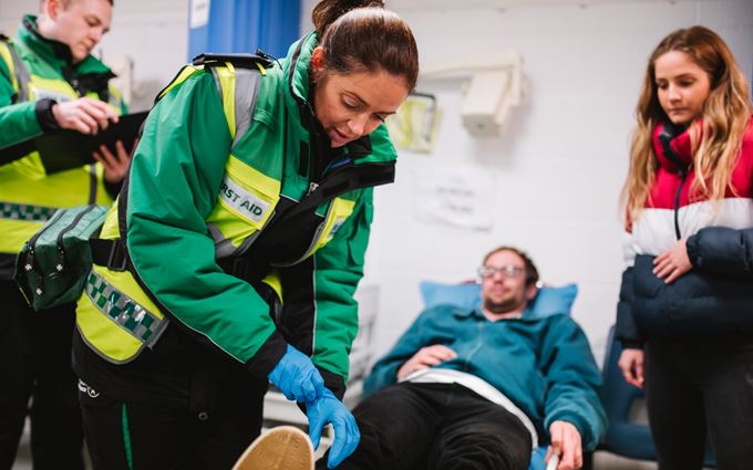 A St John Ambulance volunteer treating a football fan's leg.