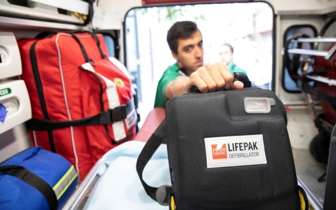 Volunteer holding a defibrillator small pod