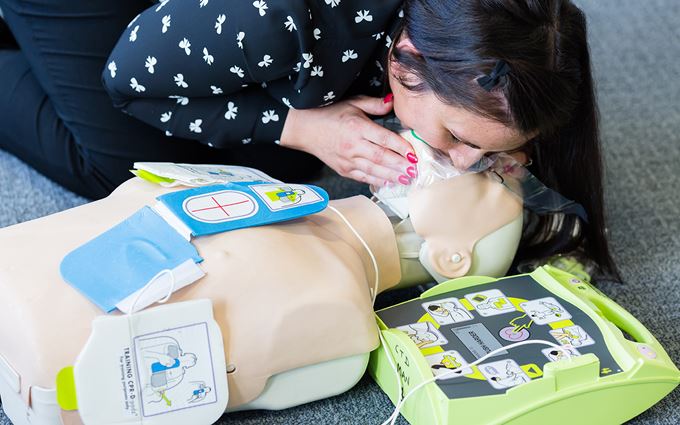 Woman practices resuscitation using a training mannequin