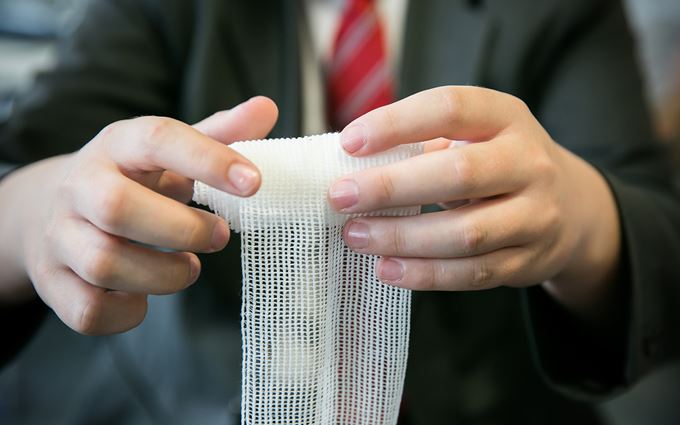School pupils learning to bandage a wound
