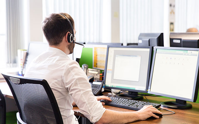 Man sitting a computer browsing training courses.