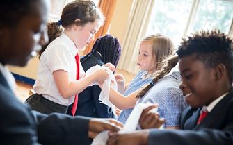 School children practising bandaging