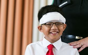 School student learning how to bandage head