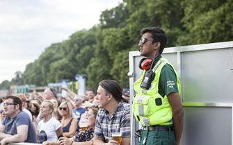 Volunteer observes crowd at outdoor summer music festival