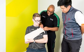First aid trainer demonstrating how to apply an arm sling