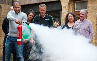 Man practices using a fire extinguisher in a fire marshal course