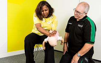 First aid participants learning how to help a choking baby