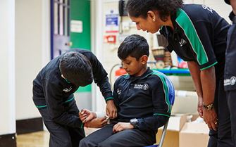 Two Badgers practising bandaging an arm